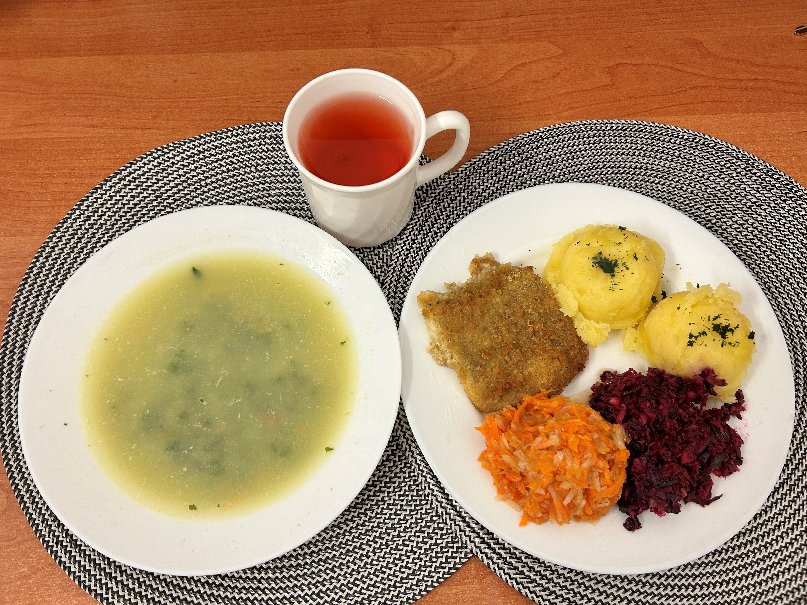 Na zdjęciu znajduje się: Szpinakowa z zacierką, Ziemniaki 200 g Ryba smażona (Dorsz), Bukiet jarzyn gotowany z olejem, Kompot owocowy, Sałatka z kapusty czerwonej z olejem